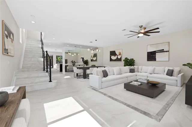 a living room with furniture ceiling fan and a rug