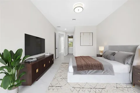 a spacious bedroom with a bed and a flat screen tv