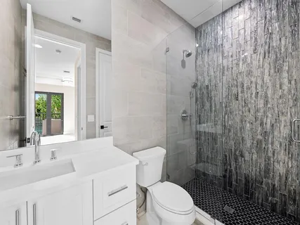 a bathroom with a sink a toilet and shower