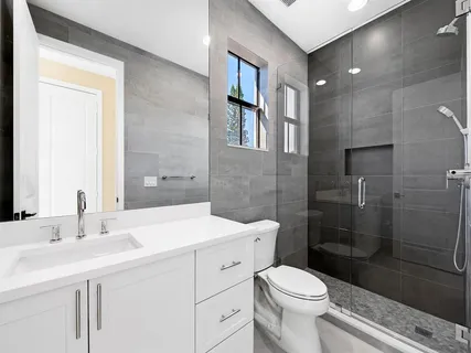 a bathroom with a sink a toilet and shower