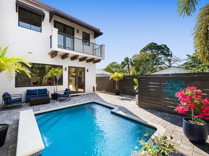 a view of a house with a swimming pool and sitting area