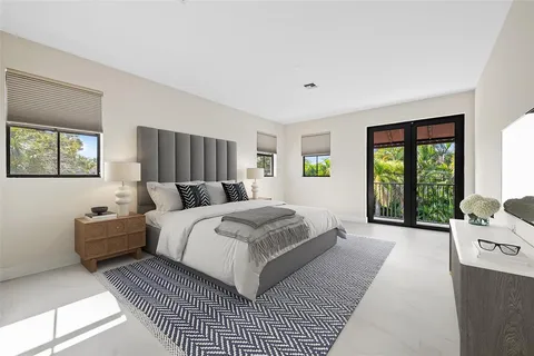 a bedroom with a bed wooden floor and window