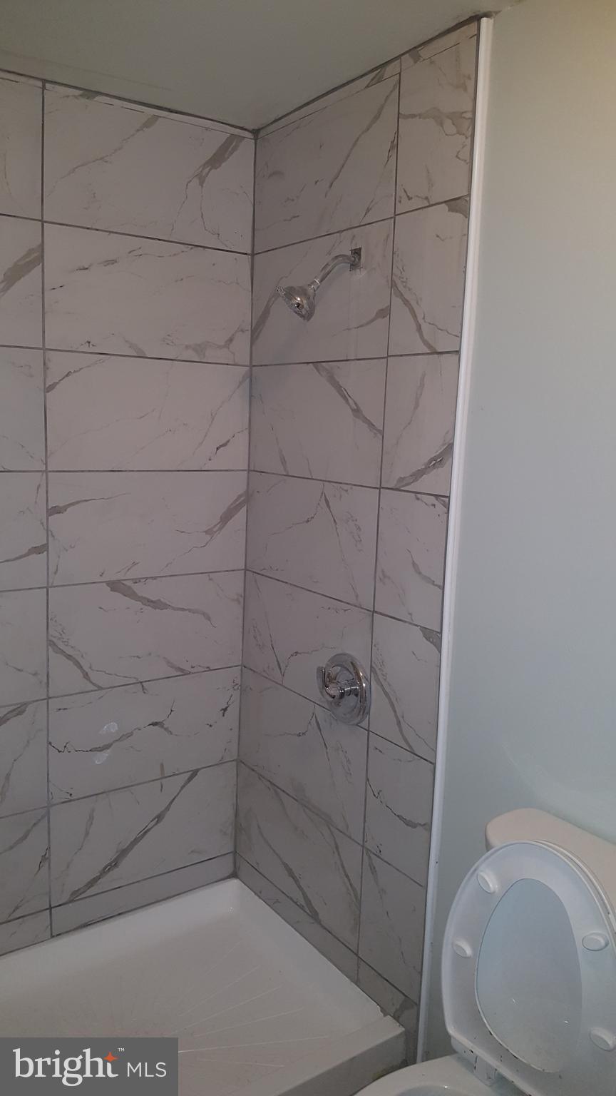 624 Stirling Street Baltimore, MD 21202 - Photo 21 of 27 a bathroom with a shower and toilet