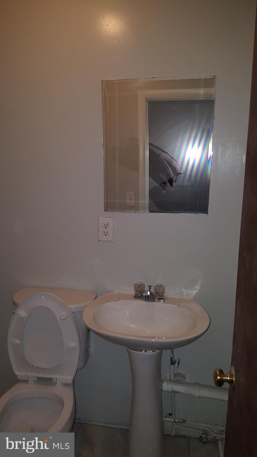624 Stirling Street Baltimore, MD 21202 - Photo 22 of 27 a bathroom with a sink toilet and a mirror
