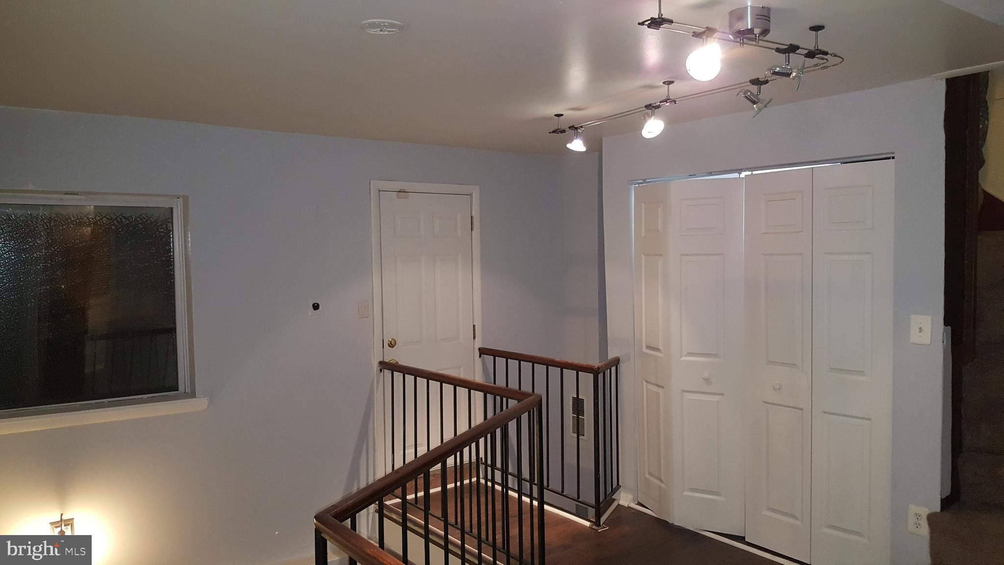 624 Stirling Street Baltimore, MD 21202 - Photo 6 of 27 a view of a hallway with wooden floor and staircase