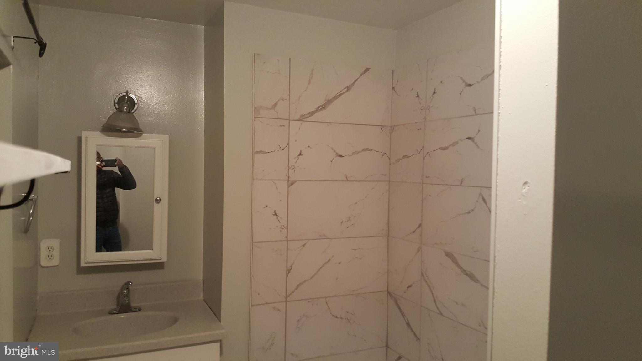 624 Stirling Street Baltimore, MD 21202 - Photo 10 of 27 a bathroom with a sink and a mirror