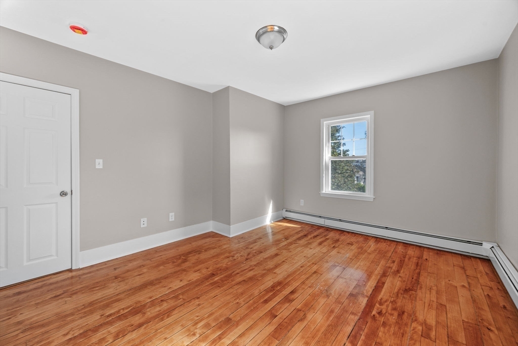 21 Lyman Street Beverly, MA 01915 - Photo 18 of 33 an empty room with wooden floor and windows