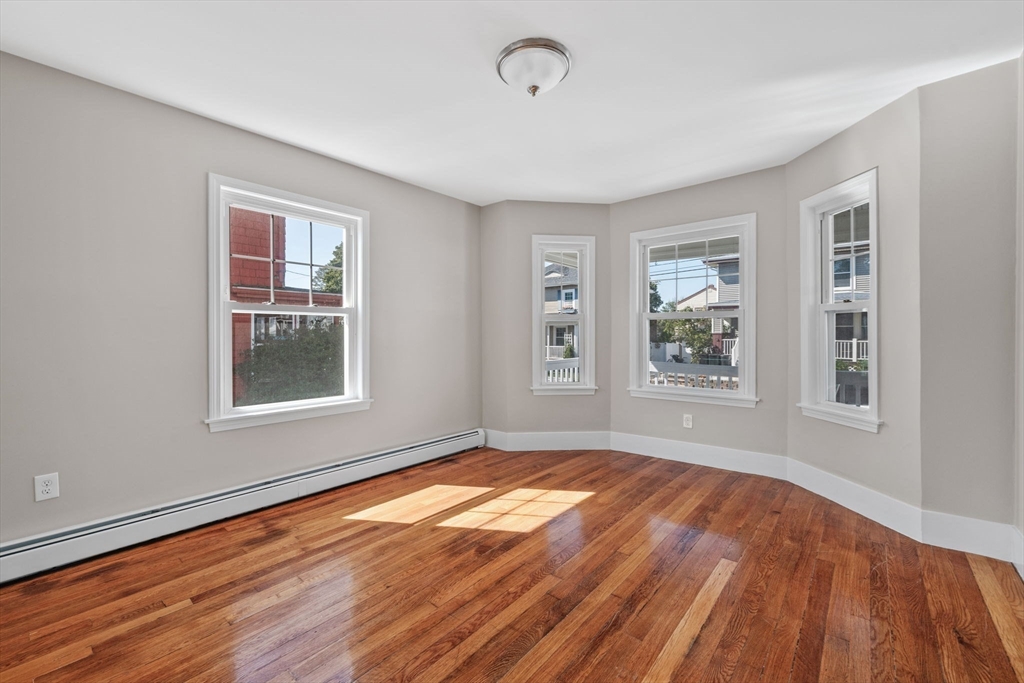 21 Lyman Street Beverly, MA 01915 - Photo 5 of 33 a view of an empty room with a window and wooden floor