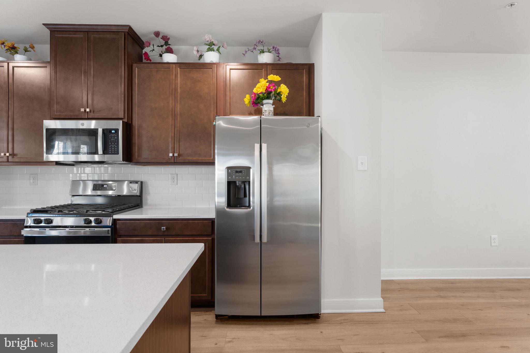 316 Longs Peak Way Exton, PA 19341 - Photo 11 of 46 a kitchen with stainless steel appliances granite countertop a refrigerator a stove a microwave oven and a sink with wooden floor