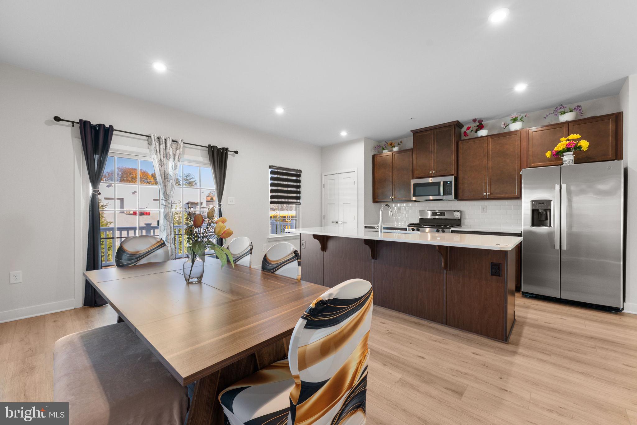 316 Longs Peak Way Exton, PA 19341 - Photo 9 of 46 a kitchen with stainless steel appliances granite countertop a stove a refrigerator a sink a dining table and chairs with wooden floor