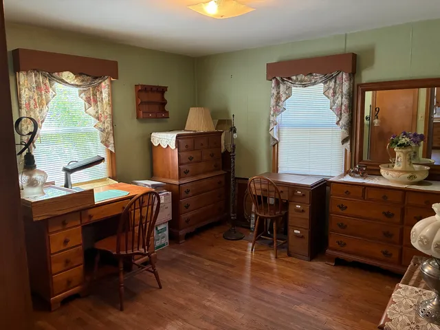 a room with furniture piano table and two windows