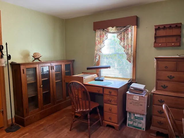 a room with a desk a window and a bookshelf