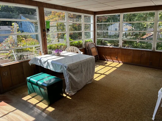 a bedroom with a bed lamp and a large window