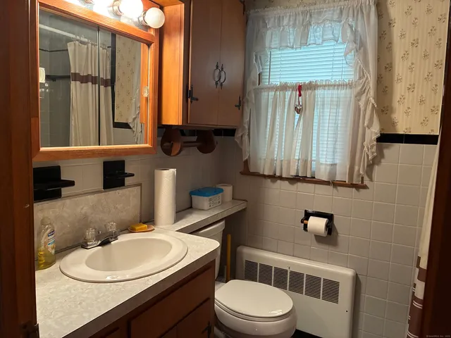 a bathroom with a toilet a sink and a mirror