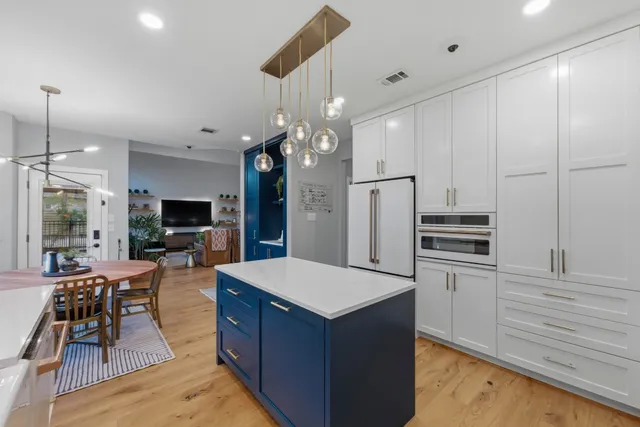a large kitchen with kitchen island a large island in it