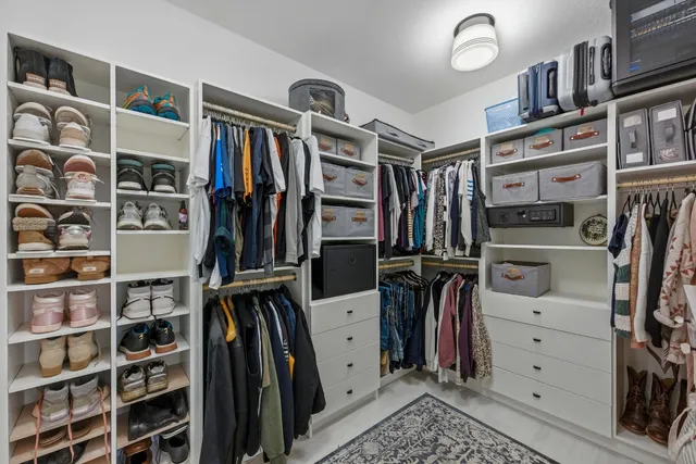 a view of walk in closet with clothes and shoes