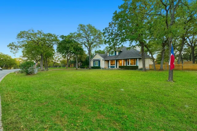 a front view of a house with a yard and trees