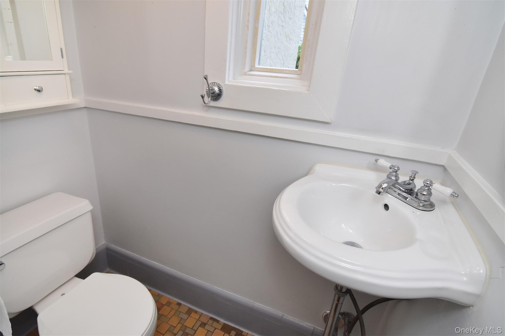370 Scarsdale Road Tuckahoe, NY 10707 - Photo 20 of 25 Powder room featuring a pedestal sink, white toilet, and a window with white trim