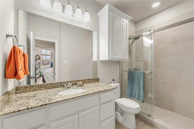 a bathroom with a granite countertop sink toilet and shower