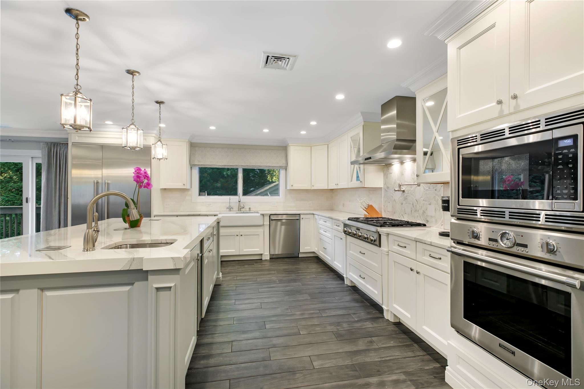 1945 Byron Road Merrick, NY 11566 - Photo 4 of 17 a kitchen with kitchen island granite countertop a sink cabinets and stainless steel appliances