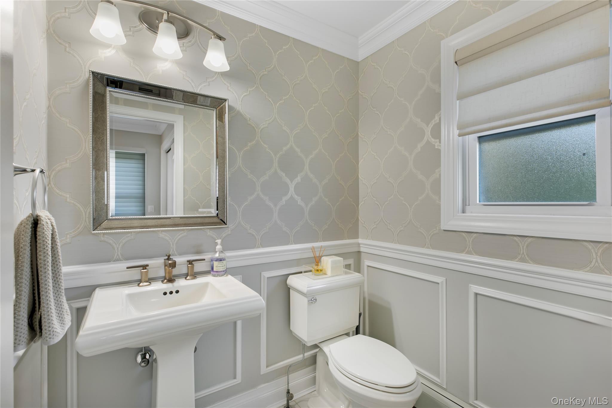 1945 Byron Road Merrick, NY 11566 - Photo 7 of 17 a bathroom with a toilet a sink a mirror and vanity