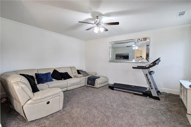 a living room with furniture and a ceiling fan