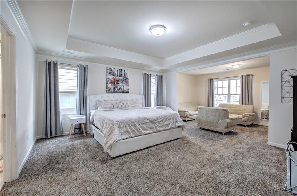 218 Orchard Trail Canton, GA 30115 - Photo 19 of 39 a spacious bedroom with a bed and a couch