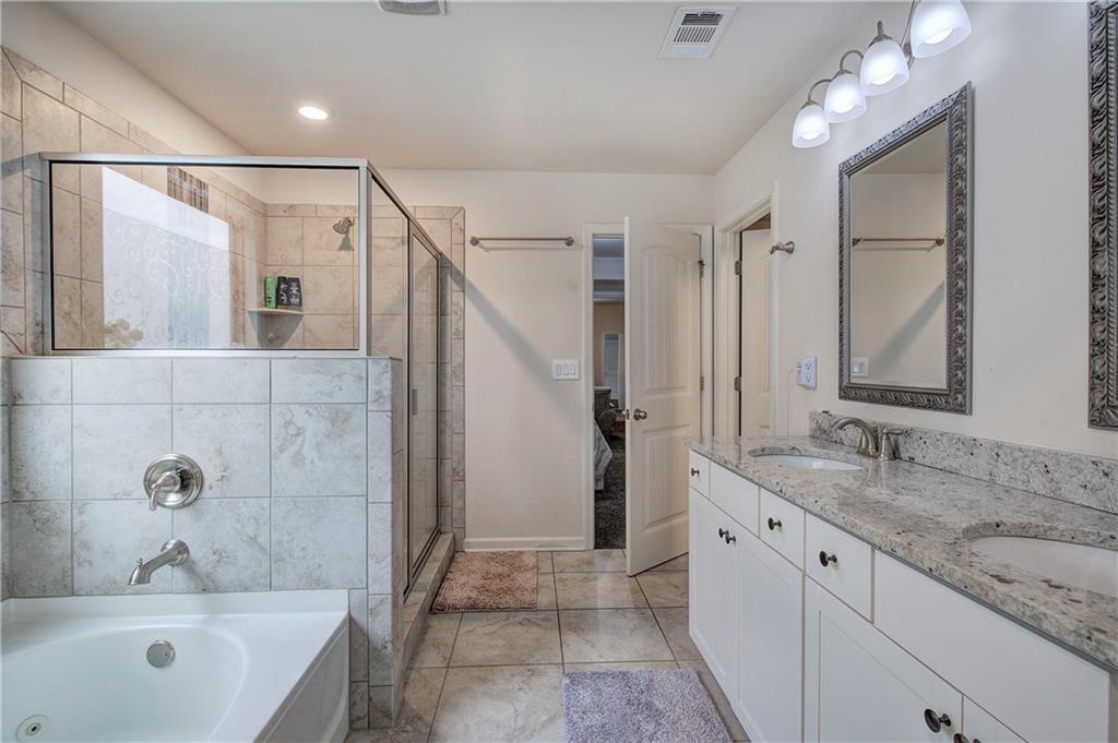 218 Orchard Trail Canton, GA 30115 - Photo 24 of 39 a bathroom with a granite countertop sink a mirror a bathtub and shower
