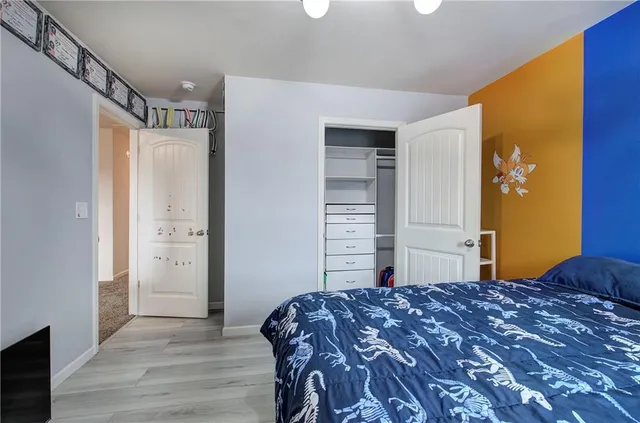 a bedroom with a large bed and wooden floor