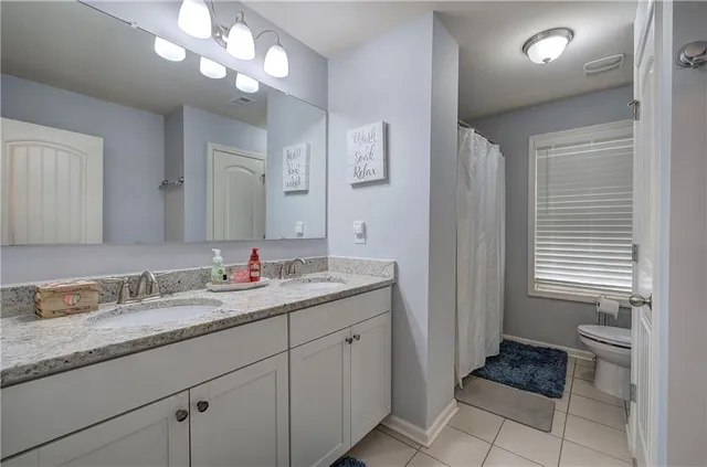 a bathroom with a granite countertop sink a light fixture and a mirror