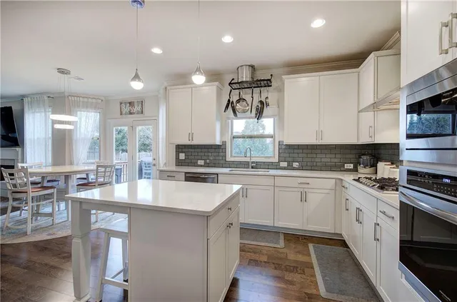 a kitchen with stainless steel appliances granite countertop a sink stove and refrigerator