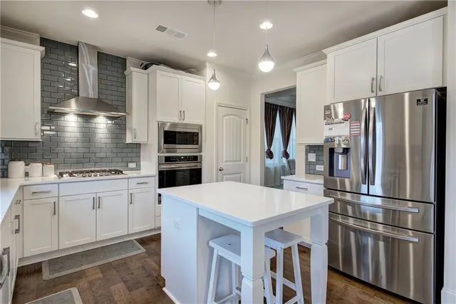 a kitchen with stainless steel appliances a refrigerator and a stove top oven
