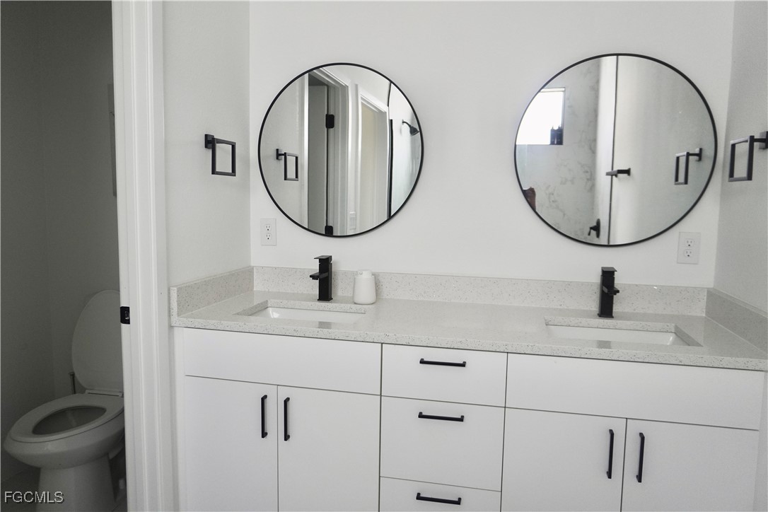 2608 25th Street West Lehigh Acres, FL 33971 - Photo 12 of 27 a bathroom with 2 sink and a mirror