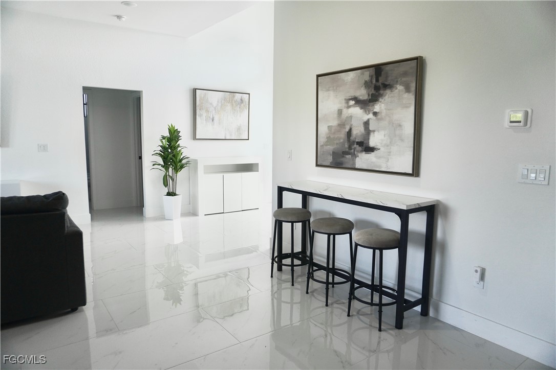 2608 25th Street West Lehigh Acres, FL 33971 - Photo 13 of 27 a view of a dining area with furniture and a potted plant