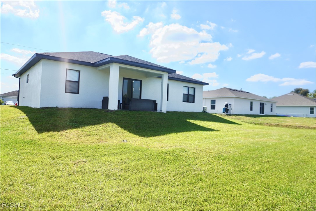 2608 25th Street West Lehigh Acres, FL 33971 - Photo 2 of 27 a view of a house with swimming pool and a yard
