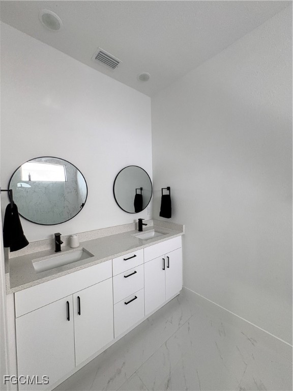 2608 25th Street West Lehigh Acres, FL 33971 - Photo 22 of 27 a bathroom with a double vanity sink and mirror