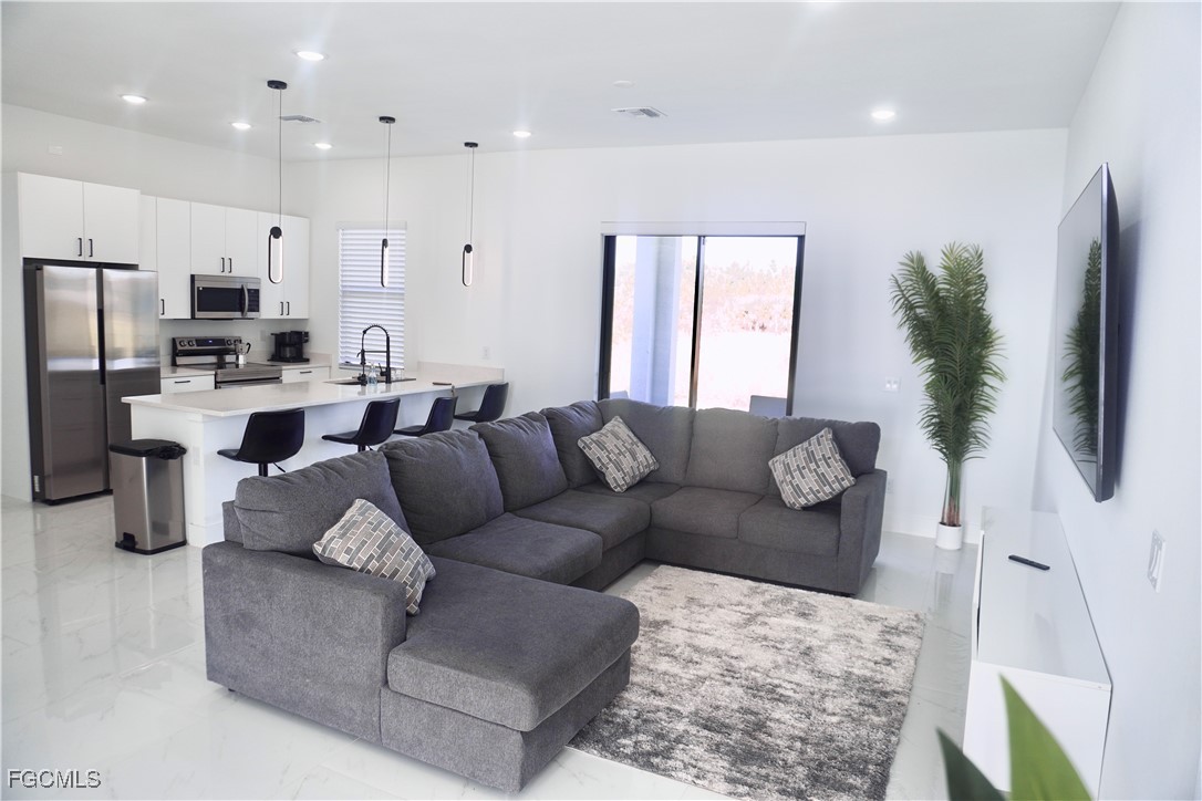 2608 25th Street West Lehigh Acres, FL 33971 - Photo 3 of 27 a living room with furniture and a flat screen tv
