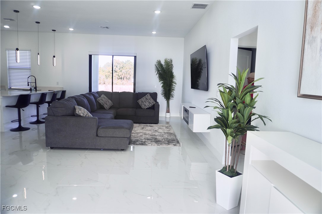 2608 25th Street West Lehigh Acres, FL 33971 - Photo 4 of 27 a living room with furniture potted plant and a window