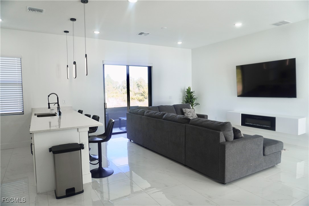 2608 25th Street West Lehigh Acres, FL 33971 - Photo 5 of 27 a living room with furniture a flat screen tv and a window