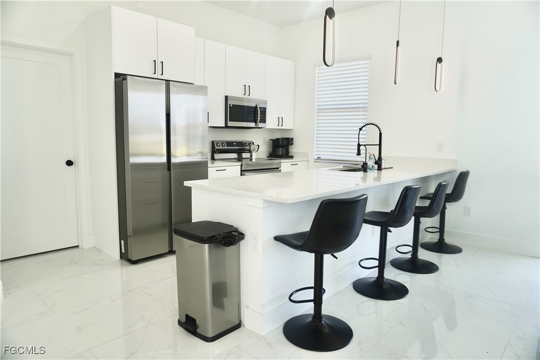 2608 25th Street West Lehigh Acres, FL 33971 - Photo 6 of 27 a kitchen with stainless steel appliances granite countertop a sink a stove and refrigerator