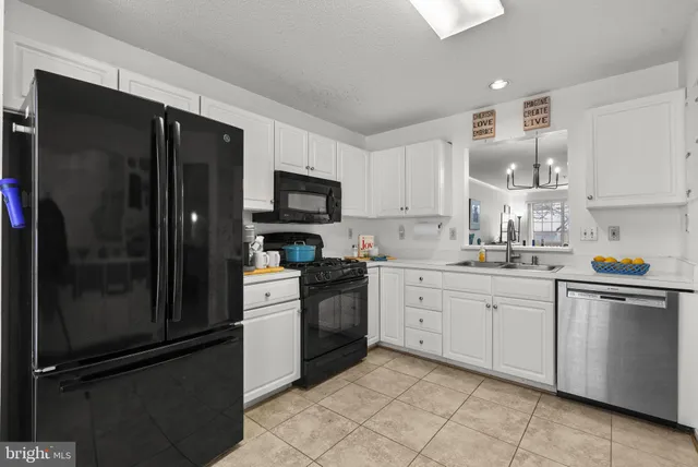 a kitchen with granite countertop stainless steel appliances and white cabinets