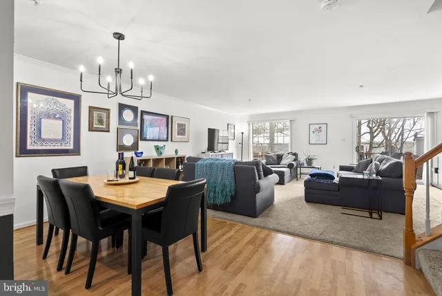 a view of a dining room with furniture a chandelier and wooden floor
