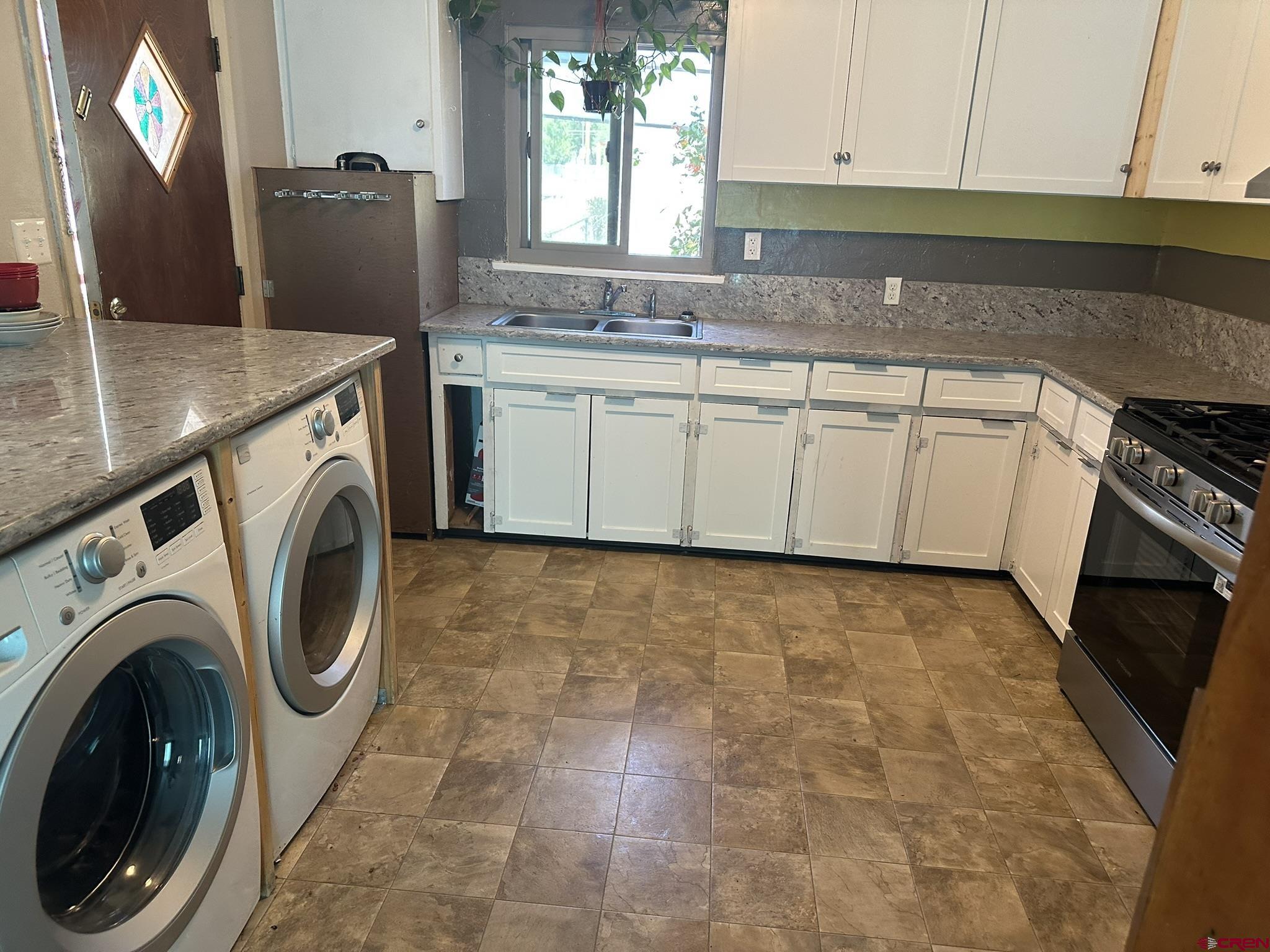 435 South Elm Street Cortez, CO 81321 - Photo 4 of 17 a kitchen with stainless steel appliances granite countertop a sink a stove a washer and dryer