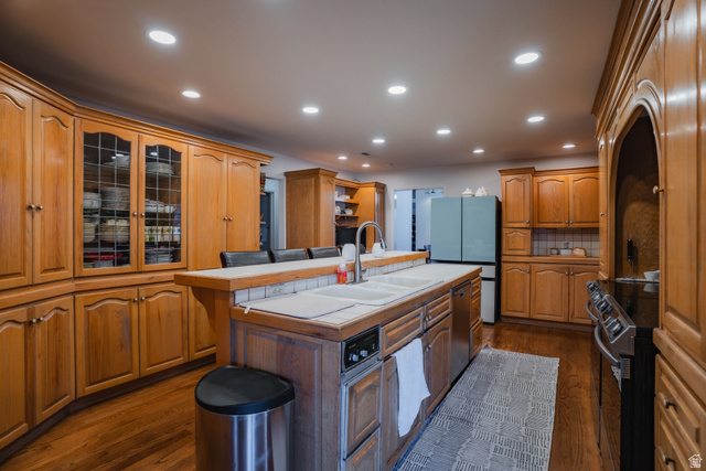980 Cactus Circle St. George, UT 84790 - Photo 8 of 77 Kitchen featuring recessed lighting, dark wood-type flooring, a kitchen island with sink, wood finish cabinets, and electric stove