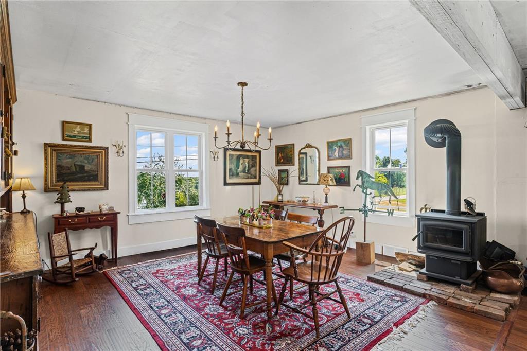 206 Lee Road Grove City, PA 16127 - Photo 33 of 44 a dining room with wooden floor a chandelier a wooden table and chairs