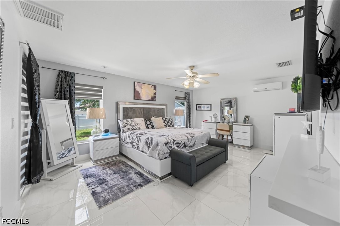 22 Nelson Road South Cape Coral, FL 33991 - Photo 26 of 43 a bedroom with a bed a flat screen tv and a fireplace