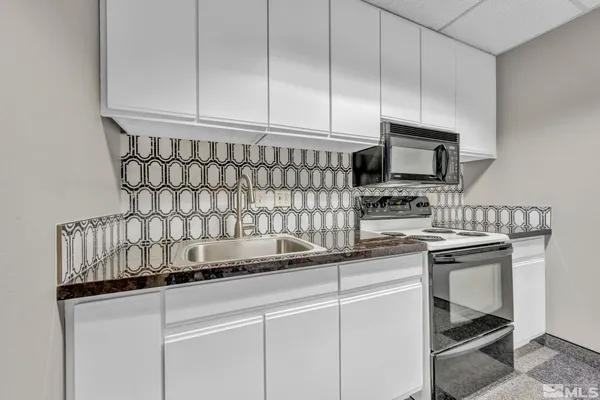 a kitchen with appliances a sink and cabinets