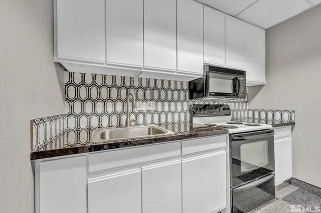 a kitchen with appliances a sink and cabinets