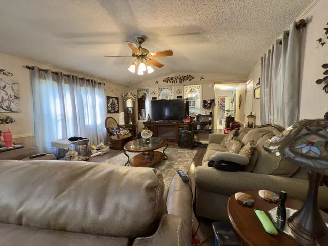 a living room with furniture a large window and flat screen tv
