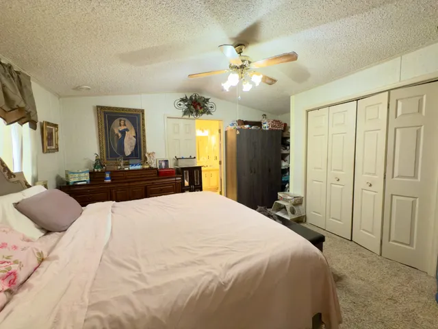 a bedroom with a large bed and a chandelier